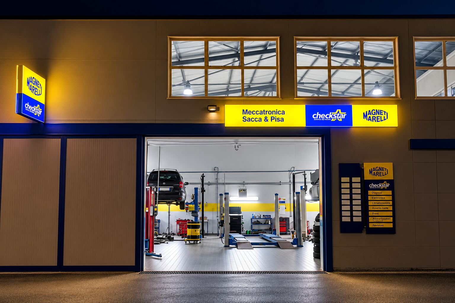 Ingresso dell’autofficina Saccà e Pisa con insegne blu e gialle e area di lavoro